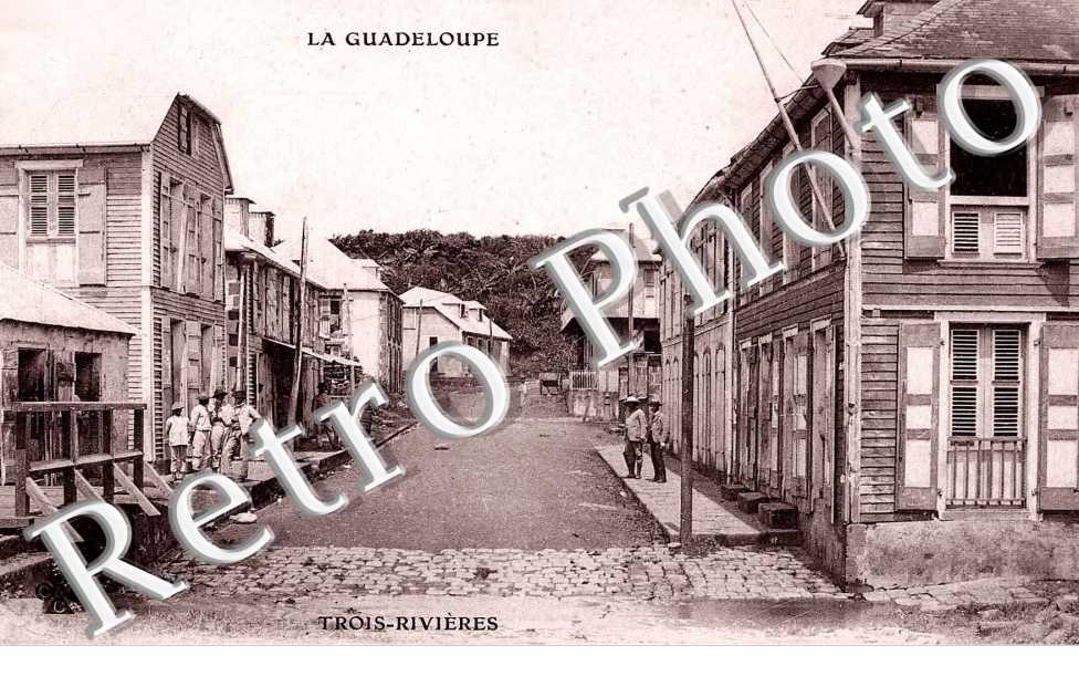 LA GUADELOUPE ( UNE RUE 4 HOMMES SUR TROTTOIRE A GAUCHE ET 2 A DROITE)