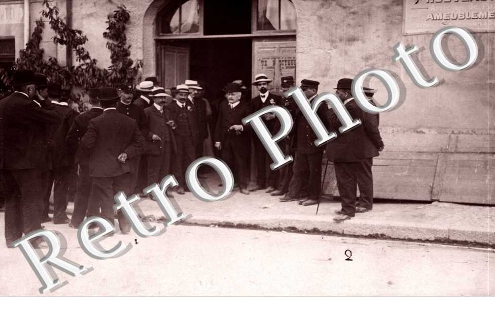 Reunion de personnes devant la Porte d'une Fabrique de Meubles