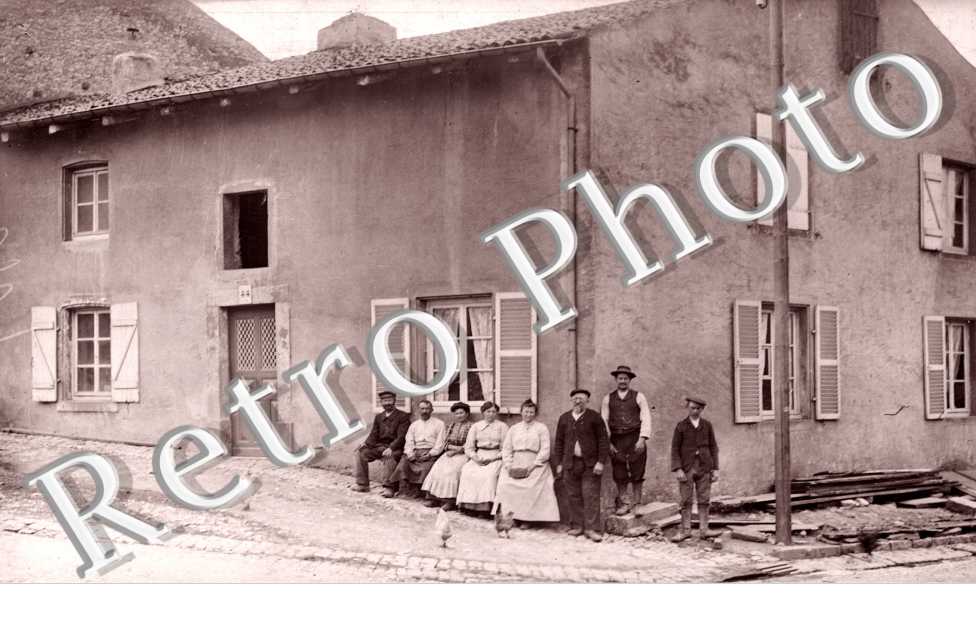 Groupe d'hommes et de femmes à l'angle d'une maison