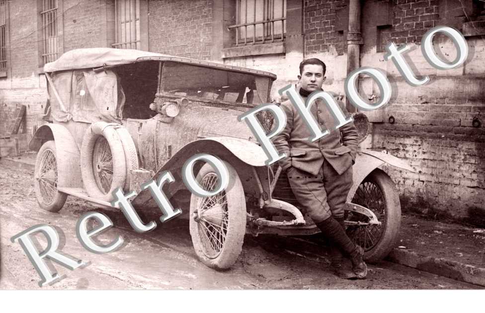(un homme posant devant son auto)